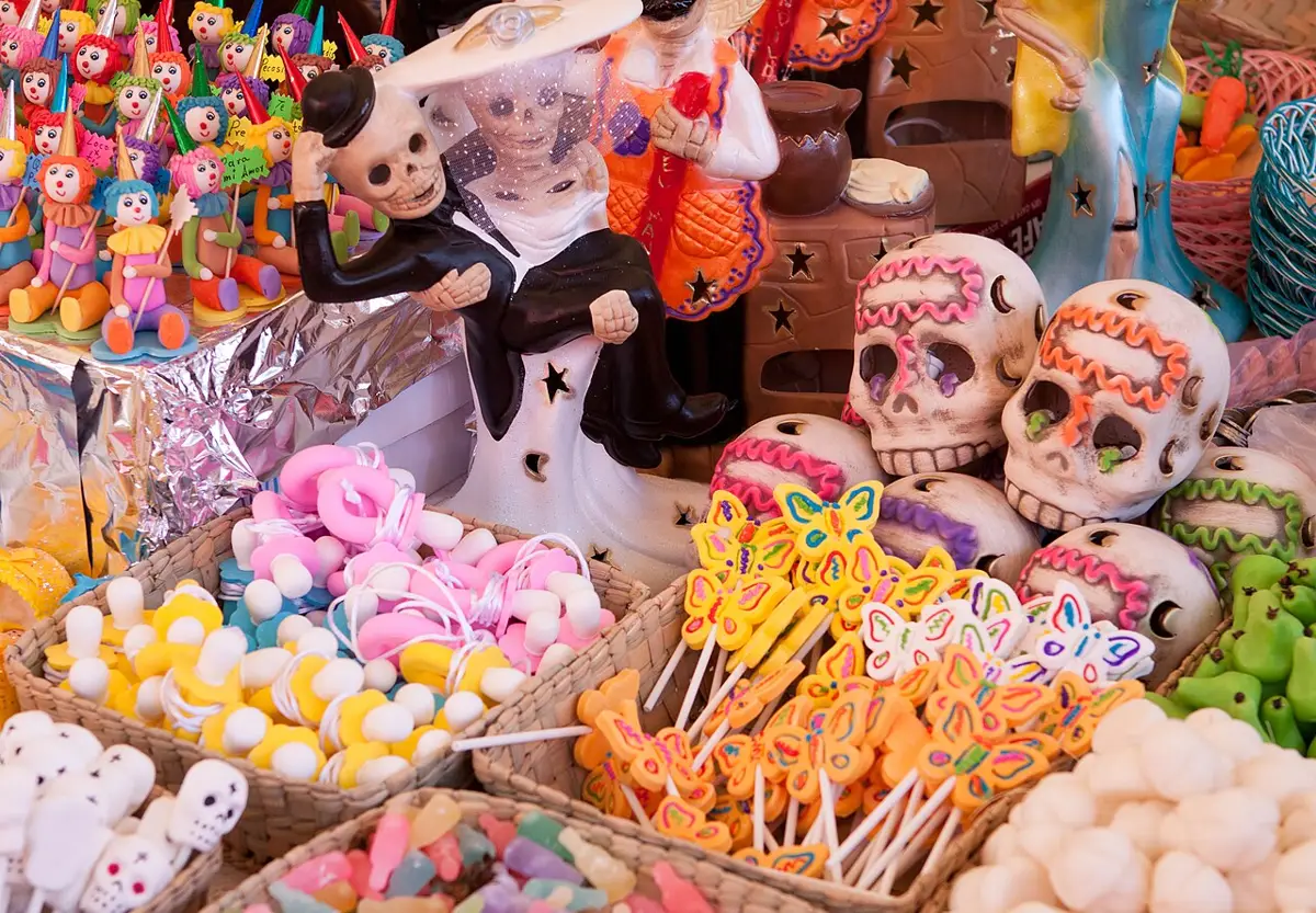 Doces e enfeites típicos do Día de los Muertos, como caveiras de açúcar e pirulitos em formato de borboleta, em um mercado mexicano.