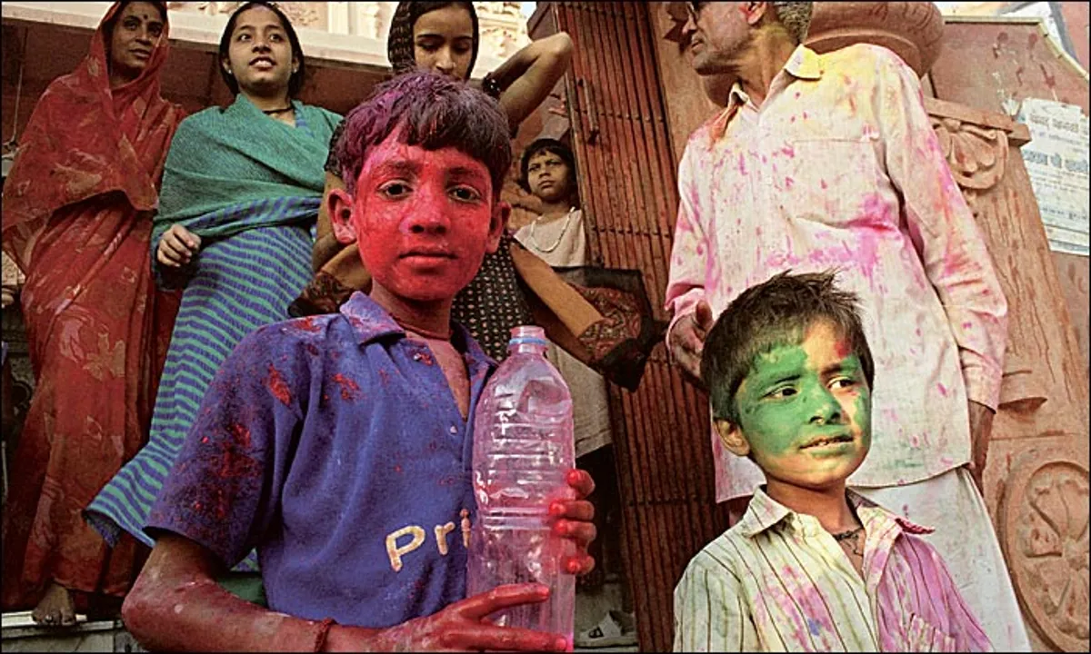 Crianças brincando durante o Holi, o festival das cores na Índia, com seus rostos cobertos por pó colorido.