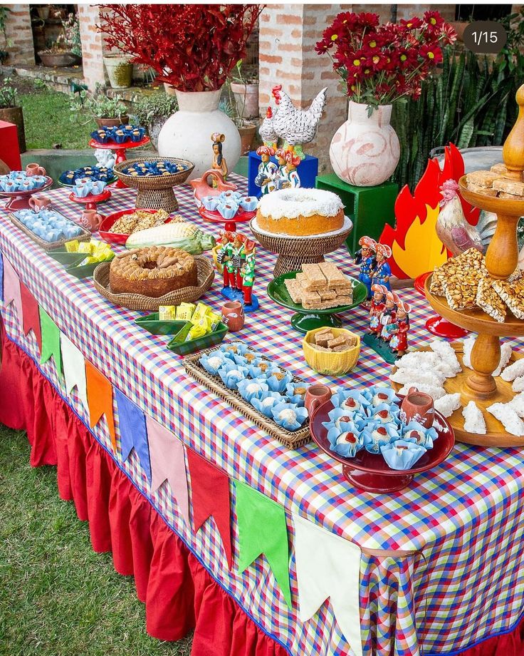 Mesa decorada com comidas típicas de festa junina e bandeirinhas coloridas