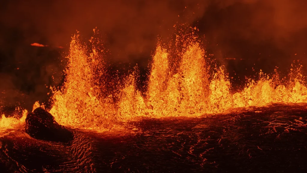 Explosão de lava em erupção, com chamas e estalos do vulcão em plena atividade.