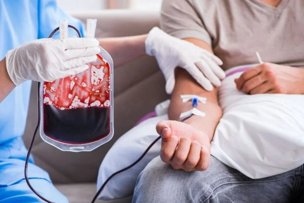 Profissional de saúde realizando uma transfusão de sangue em um paciente, evidenciando a importância da doação