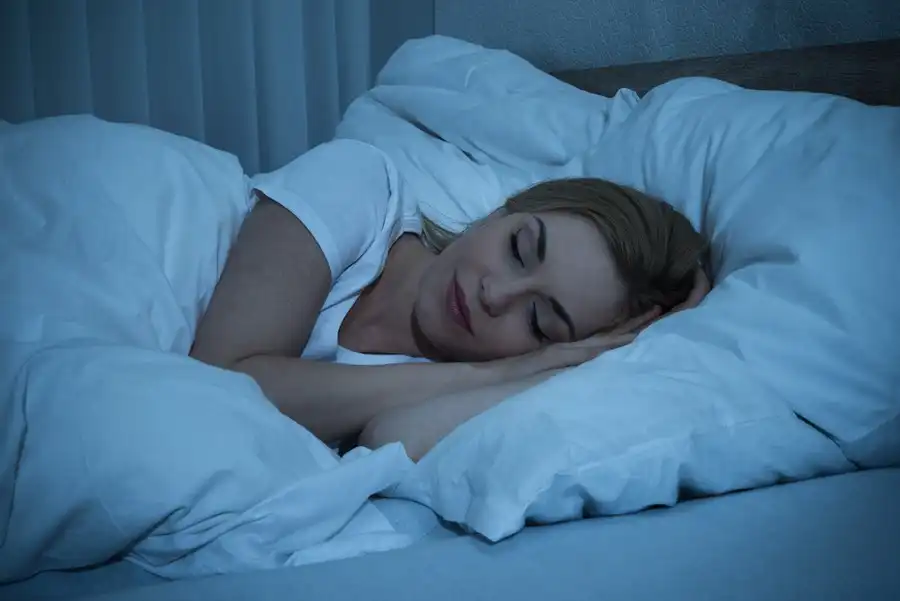 Mulher dormindo tranquilamente na cama, em um ambiente seguro e confortável, simbolizando a sensação de proteção ao fechar a porta do quarto à noite.