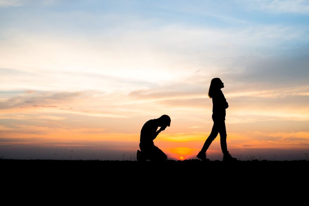 Casal em processo de separação ao pôr do sol simbolizando superação após término.