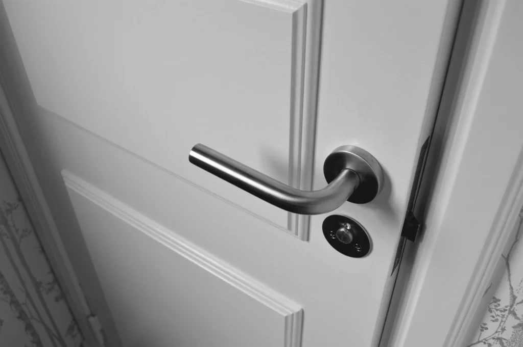 "Fechadura e maçaneta de uma porta, simbolizando o ato de fechar a porta do quarto à noite para maior sensação de segurança.