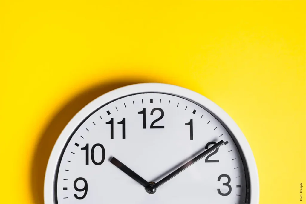elógio de parede mostrando as 10:10 com fundo amarelo.
