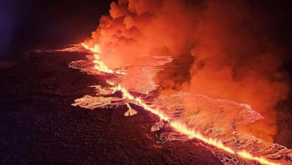 Imagens aéreas do vulcão da Islândia em erupção, mostrando a lava fluindo intensamente.